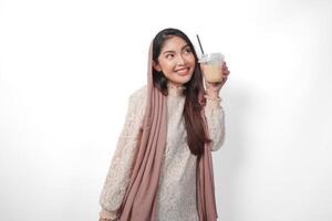 lächelnd asiatisch Muslim Frau im Kopftuch Schleier Hijab halten Kaffee im ein Plastik Tasse warten zum iftar zu trinken. Ramadan Konzept foto