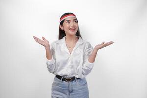 aufgeregt asiatisch Frau tragen Flagge Stirnband präsentieren und zeigen beim das Kopieren Raum auf das Seite, lächelnd breit und Stehen auf isoliert Weiß Hintergrund. Unabhängigkeit Tag Werbung Konzept foto