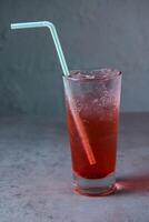 gesund Shirley Tempel Limonade serviert im Glas mit Stroh Seite Aussicht auf grau Hintergrund foto