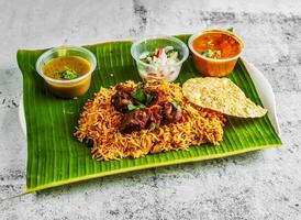 Hammelfleisch Briyani Reis pulao mit Salat, Chutney, Raita und Soße serviert im Gericht isoliert auf Banane Blatt oben Aussicht von indisch und Singapur würzig Essen foto