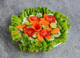 frisch Grün Salat mit Gurke, Karotte, Tomate, Zwiebel und Grüner Salat Blatt serviert im Gericht isoliert auf grau Hintergrund Seite Aussicht von indisch gesund und pakistanisch Essen foto