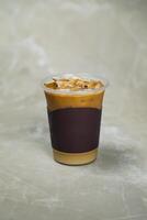 vereist vermischt Karamell Kaffee serviert im Einweg Tasse isoliert auf grau Hintergrund oben Aussicht von Cafe Dessert foto