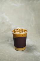 vereist vermischt Karamell Kaffee serviert im Einweg Tasse isoliert auf grau Hintergrund oben Aussicht von Cafe Dessert foto