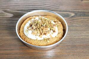 Kunafa Sahne Belag mit Nussbaum, Pistazie und Cashew Nuss serviert im Gericht isoliert auf Tabelle Seite Aussicht von Arabisch Dessert Essen foto