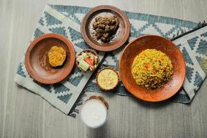 hasch bhuna khichuri Combo mit Ei Anlage, korma Karahi, Fleisch, Salat, borhani und firni serviert im Gericht isoliert auf Matte oben Aussicht von indisch und Bangladesch Essen foto