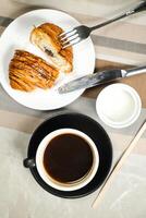 Americano Kaffee serviert im Tasse mit Croissant, Puff Gebäck, Brot und Messer isoliert auf Serviette oben Aussicht Cafe Frühstück foto
