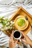 Zitrone Pistazie Krapfen mit Tasse von Kaffee, Gabel und Blumen serviert im Teller isoliert auf hölzern Tablett oben Aussicht von gebacken Frühstück Essen foto