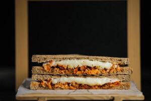 Hähnchen Tikka Minze gegrillt Sandwich isoliert auf hölzern Tafel Seite Aussicht von schnell Essen auf dunkel Hintergrund foto