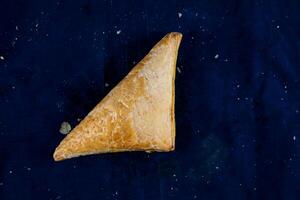 Gemüse Pastetchen oder Samosa isoliert auf Blau Hintergrund oben Aussicht von Bohnenkraut Snack Essen foto