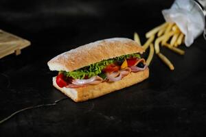 Ciabatta geräuchert Schinken Sandwich isoliert auf hölzern mit Mayonnaise tauchen und Französisch Fritten Eimer Tafel Seite Aussicht von Italienisch schnell Essen auf grau Hintergrund foto