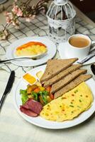 ausgestopft Omelette mit bown brot, Fleisch, Gemüse Salat umfassen Tomate, Kartoffel, Grüner Salat Blatt und Karotte mit Tee, Kaffee, und Süss Melone serviert auf Essen Tabelle oben Aussicht gesund Frühstück foto