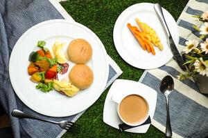 Ei Benedikt Schieberegler mit Gemüse Salat umfassen Tomate, Kartoffel, Grüner Salat Blatt und Karotte mit Tee, Kaffee, und Süss Melone serviert auf Essen Tabelle oben Aussicht gesund Englisch Frühstück foto