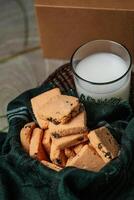 knackig Kekse Kekse serviert im Teller mit Plätzchen Box und Glas von Milch isoliert auf Tabelle Seite Aussicht von amerikanisch Cafe gebacken Essen foto