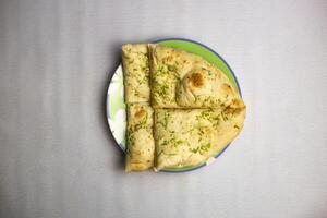 Knoblauch nan oder Knoblauch Brot mit Peperoni Belag mit Koriander serviert im Teller isoliert auf Hintergrund oben Aussicht von bangladesch, indisch und pakistanisch traditionell würzig Essen foto