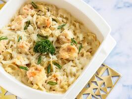 Garnelen Fettuccine mit Sahne Soße serviert im Gericht isoliert auf Tabelle Nahansicht oben Aussicht von Italienisch Essen foto