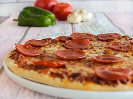 Peperoni Pizza Nahansicht Belag mit Paprika, Pilz, Tomate und Oliven serviert im Gericht isoliert auf Tabelle Seite Aussicht von Arabisch Fast Food foto