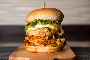 doppelt Burger mit Hähnchen Pastetchen, Käse und Mayonnaise isoliert auf hölzern Tafel oben Aussicht von Fast Food foto