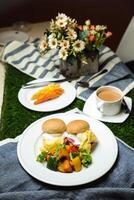Ei Benedikt Schieberegler mit Gemüse Salat umfassen Tomate, Kartoffel, Grüner Salat Blatt und Karotte mit Tee, Kaffee, und Süss Melone serviert auf Essen Tabelle oben Aussicht gesund Englisch Frühstück foto