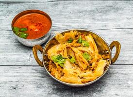 Hähnchen kothu parotta mit Curry serviert im Gericht isoliert auf hölzern Tabelle oben Aussicht von indisch würzig Essen foto