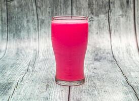 Rose Milch serviert im Glas isoliert auf hölzern Tabelle oben Aussicht von indisch gesund trinken foto