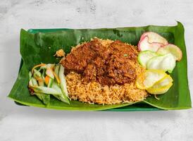 Rindfleisch Biryani Reis oder pulao mit Salat serviert im Gericht isoliert auf Banane Blatt oben Aussicht von Singapur Essen foto