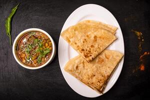 Paratha mit dal Chana oder Chanay serviert im Gericht isoliert auf dunkel Hintergrund oben Aussicht indisch Gewürze, Bangladesch und pakistanisch Essen foto