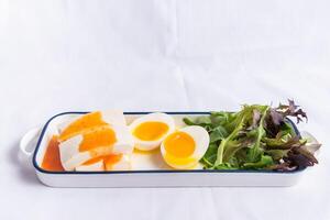 Vietnamesisch Tofu mit sonnig Eier und Salat Blätter serviert im Tablett isoliert auf Hintergrund Seite Aussicht von Vietnamesisch Essen foto