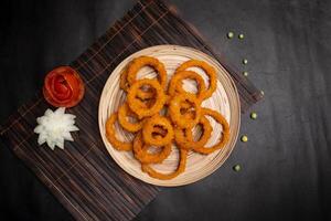 tief gebraten Zwiebel Ringe serviert im Gericht isoliert auf Serviette Matte oben Aussicht von Fast Food foto