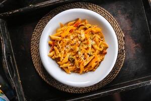 Pasta mit Tomate Soße serviert im Gericht isoliert auf rot Matte oben Aussicht auf Tabelle Arabisch Essen foto