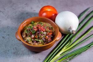 Foul Medames mit Tomate und Knoblauch serviert im Schüssel isoliert auf grau Hintergrund oben Aussicht von Bahrain Essen foto