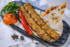 Hähnchen suche Kabab Fleisch Kebab mit Pita-Brot brot, Tomate und Zwiebel serviert im Gericht isoliert auf Essen Tabelle oben Aussicht von Mitte Osten Gewürze foto