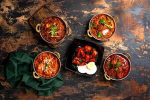 sortiert Karahi Essen Hähnchen Karahi, Hammelfleisch Korma, Rindfleisch qorma, Lamm Kadahi Masala, Tikka Kabab serviert auf Essen Tabelle oben Aussicht von indisch Gewürze foto