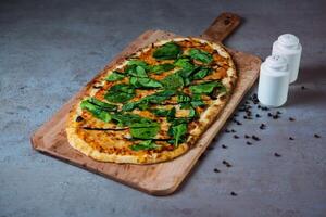 Rocca Pizza mit schwarz Pfeffer Portion auf hölzern Schneiden Tafel isoliert auf grau Hintergrund oben Aussicht von Fast Food foto