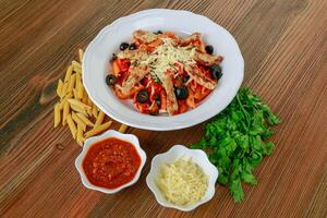 gegrillt Hähnchen Pasta mit schwarz Olive, Chili Soße und Koriander serviert im Gericht isoliert auf Tabelle Seite Aussicht von Arabisch Essen foto