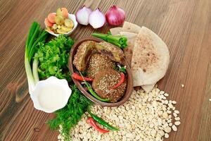 Falafel ausgestopft Pfeffer mit Zwiebel, Frühling Zwiebel und Koriander serviert im Gericht isoliert auf hölzern Tabelle oben Aussicht von Arabisch Essen foto