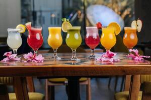 sortiert Obst Saft von Apfel, Erdbeere, Wassermelone, Leidenschaft Frucht, Mango, Orange serviert im Glas isoliert auf Tabelle Seite Aussicht von gesund Morgen Arabisch trinken foto