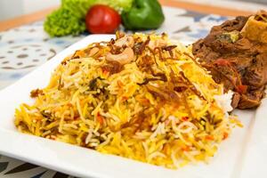 Fleisch Biryani Reis mit Cashew Nuss serviert im Gericht isoliert auf Tabelle oben Aussicht von Arabisch Essen foto