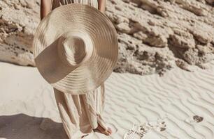 Frau halten groß Hut auf Strand foto