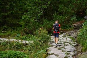 Mann Wandern im Wald mit Rucksack foto