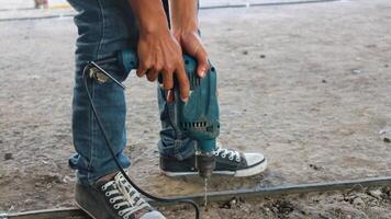 bauarbeiter, der bohrhammer verwendet, der betonoberfläche bohrt foto