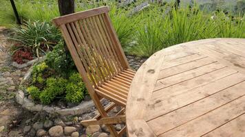 hölzern Tisch, Stühle und Regenschirm draußen im Garten foto