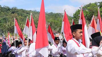 Ambarawa, August 17 .. 2023. indonesisch Studenten bringen rot Weiß Flaggen im Zeremonie feiern Unabhängigkeit Tag. foto