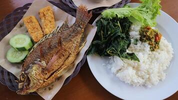 gebraten Tilapia Fisch lalapan Nila goreng mit Weiß Reis, Chili Soße und Gemüse foto