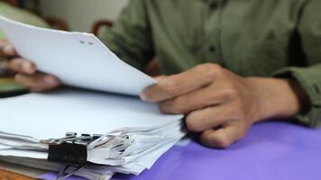 Geschäftsmann vorbereiten Berichte Papiere. Haufen von unvollendet dokumentieren erreicht mit Papier Clip. foto