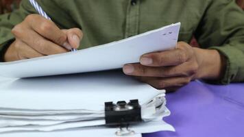 Geschäftsmann vorbereiten Berichte Papiere. Haufen von unvollendet dokumentieren erreicht mit Papier Clip. foto