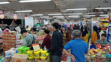 Semarang, Indonesien - - März 10, 2024 - - Menschen beim Supermarkt. Verbraucher Besuch Lebensmittelgeschäft speichern, Einkaufen. Käufer, Kunden mit Wagen foto