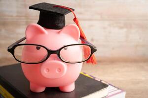 Schweinchen Bank tragen Brille mit mit Münzen und Taschenrechner Speichern Bank Bildung Konzept. foto