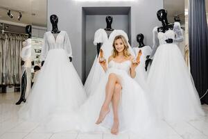 das zukünftige Braut ist tragen ein Hochzeit Kleid beim ein passend zu im das Salon, wählen Schuhe zum das Hochzeit foto