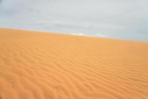Sand Düne im das Wüste mit Wolken im das Hintergrund. foto