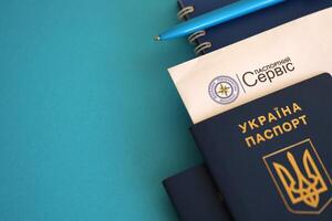 Kiew, Ukraine - - November 27, 2023 Reisepass Bedienung Logo mit International ukrainisch Reisepass und Stift foto